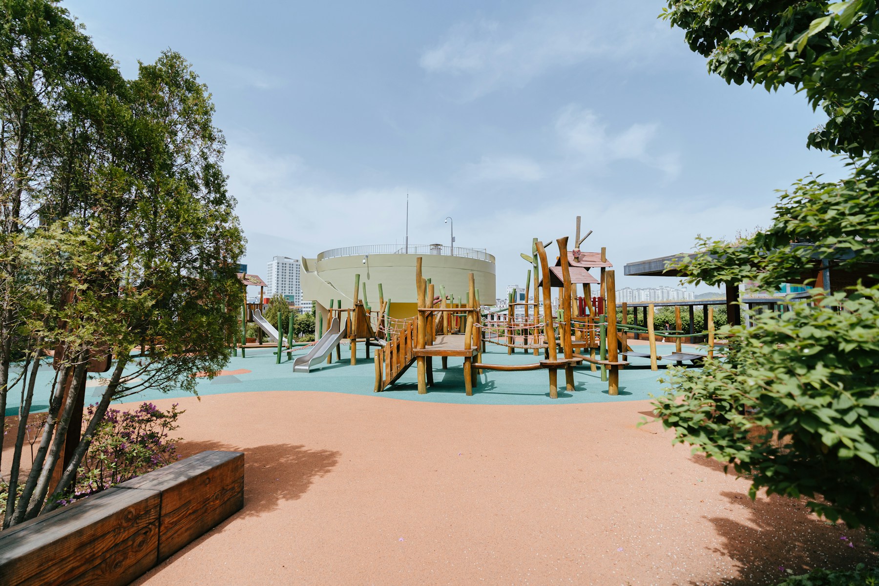 Kinderen spelen buiten in een groene speelomgeving.
